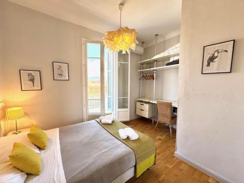 Cette chambre comprend un lit avec des oreillers jaunes et un bureau. dans l'établissement ApartHotel Riviera - Hyper Centre Musiciens - Superior 1 Bedroom Apartement AC - Balcony - 10 mn Promenade des Anglais - BALCON PALAIS EXCELSIOR 1, à Nice