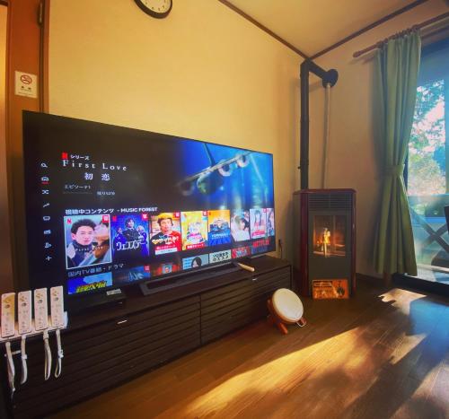 a large flat screen tv in a living room at 貸別荘MUSIC FOREST by MFR in Sasayama