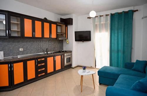 un soggiorno con un divano blu e una cucina di AURA apartaments29 a Durrës