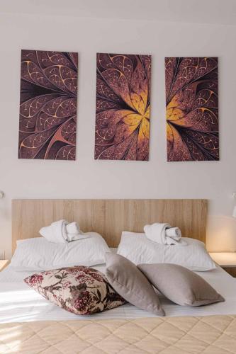 a bedroom with three pictures on the wall above a bed at NAR Royalton Accommodation in Niš