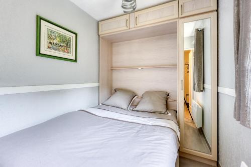 une petite chambre avec un lit dans une pièce dans l'établissement L'Alisier - climatisé à 5 min de la plage, à Six-Fours-les-Plages