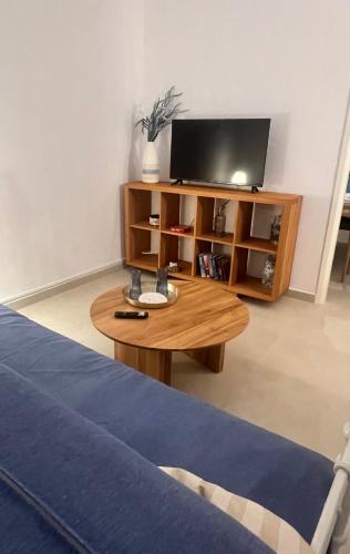 a living room with a tv and a wooden coffee table at Thalassea house1 Lipsi in Lipsoi