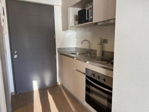a small kitchen with a sink and a stove at Apartamento Centro Maipú in Concepción
