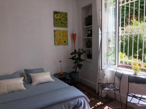 une chambre avec un lit et une grande fenêtre dans l'établissement Noctuelle, à Bourges