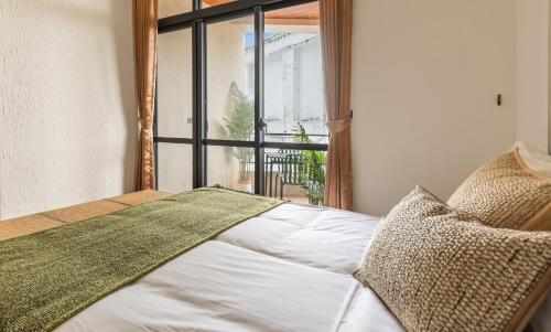 a bedroom with a bed and a large window at Sun Moon Lake ItaThao Vacation Inn with Elevator in Yuchi