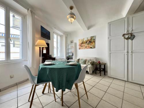 une salle à manger avec une table et des chaises vertes dans l'établissement Miky - SCLS Locations, à Cannes