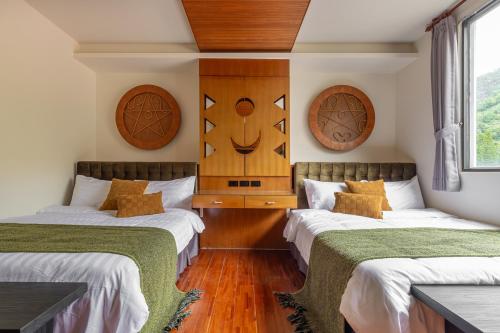two beds in a room with wood paneling at Sun Moon Lake ItaThao Vacation Inn with Elevator in Yuchi