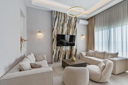 a living room with a couch and a tv at Olymp Luxury Family House in Paphos