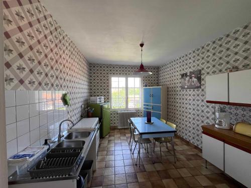 une cuisine avec un évier et une table à l'intérieur dans l'établissement Gîte 6 à 8 personnes calme et repos, à Saint-Romans-lès-Melle