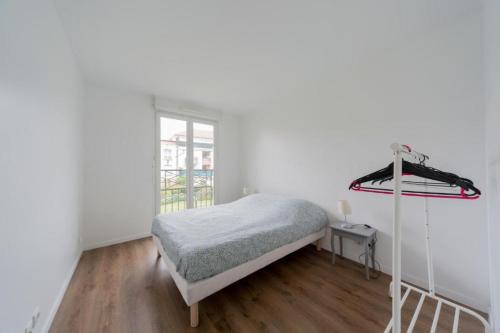 une chambre blanche avec un lit et une fenêtre dans l'établissement Le Familial - Spacieux - 8p - 10 min Disney, à Bussy-Saint-Georges