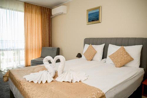 a hotel room with a bed with two swans at Paradise Hotel & Relax Center in Pomorie