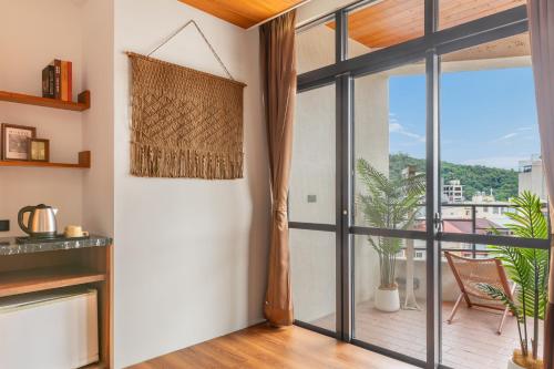 a living room with a large glass door leading to a balcony at Sun Moon Lake ItaThao Vacation Inn with Elevator in Yuchi