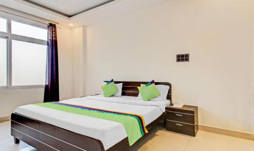 a bedroom with a large bed with green pillows at Treebo Silver Grand in Lucknow