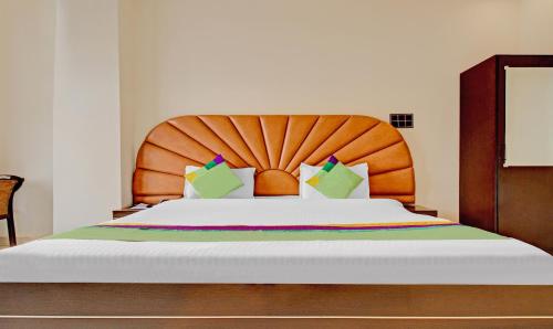 a bedroom with a large bed with a wooden headboard at Treebo Silver Grand in Lucknow