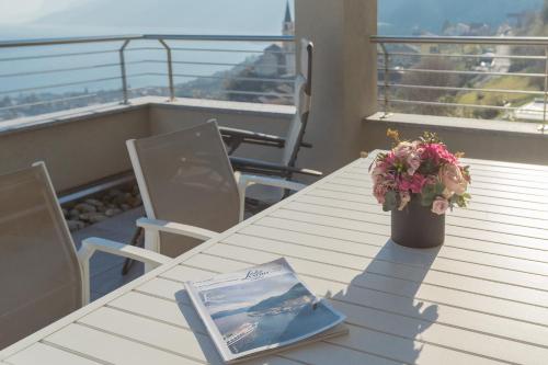 a book sitting on top of a table on a balcony at Valarin Luxury Apartments & Wellness, Vercana by Rent All Como in Vercana