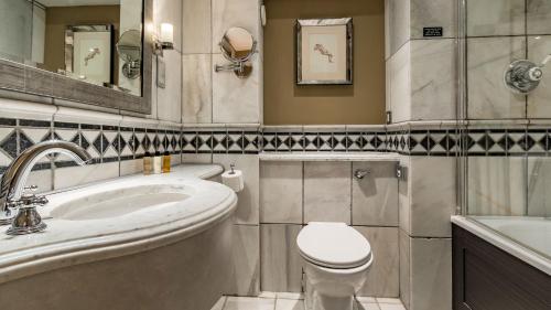 a bathroom with a toilet and a sink and a tub at Wood Hall Hotel & Spa in Wetherby
