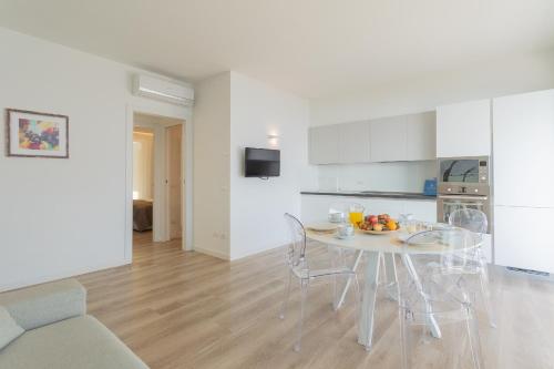 a white kitchen with a table and chairs in a room at Valarin Luxury Apartments & Wellness, Vercana by Rent All Como in Vercana