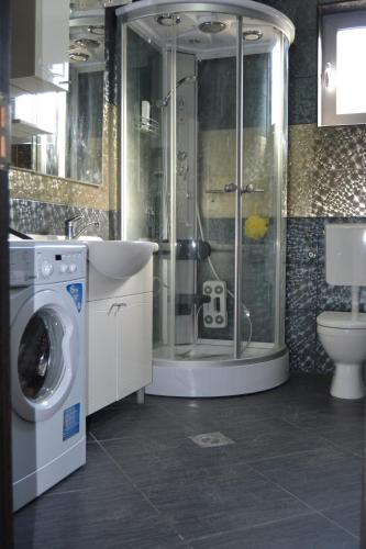 a bathroom with a shower and a washing machine at Old Town View Apartment in Budva