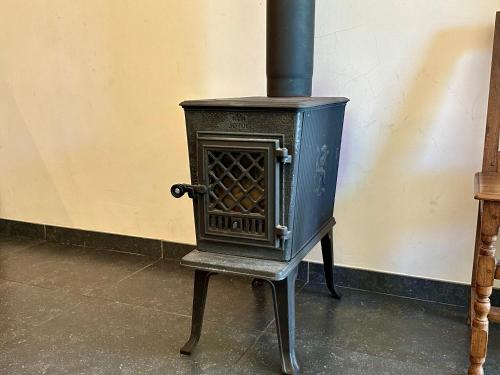 a black stove sitting on a chair in a room at Les Gîtes du Château de Bellaire in Gesves