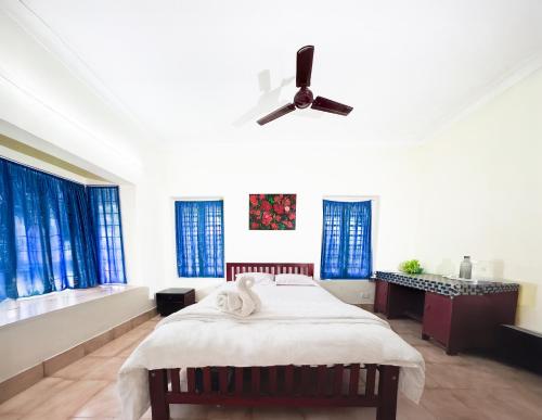 a bedroom with a bed and a ceiling fan at Riverside Group in Kakkanad