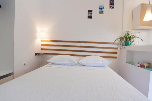 a white bed with two pillows in a room at Villa Makarana Apartments in Makarska
