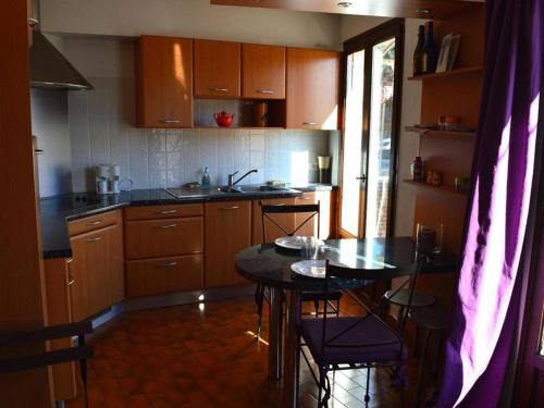 une cuisine avec une table et des chaises dans l'établissement Appart 2 pièces, 4 couchages, proche mer et commerces, balcon, animaux admis - FR-1-225C-15, à Banyuls-sur-Mer