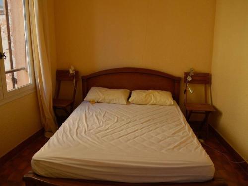 un lit avec deux oreillers dessus dans une chambre dans l'établissement Appart 2 pièces, 4 couchages, proche mer et commerces, balcon, animaux admis - FR-1-225C-15, à Banyuls-sur-Mer