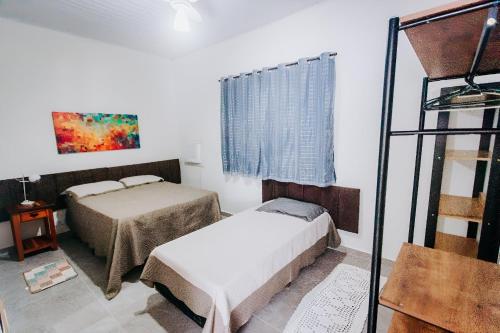 ein Schlafzimmer mit zwei Betten in einem Zimmer in der Unterkunft Casa c/ Piscina e Área Gourmet Perto da Praia in São Sebastião