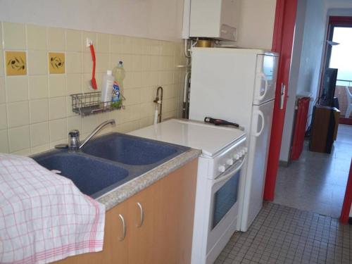 une cuisine avec un évier et un réfrigérateur dans l'établissement Appartement lumineux 2 pièces avec vue mer, parking et Wifi à Banyuls-sur-Mer - FR-1-225C-16, à Banyuls-sur-Mer