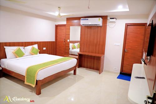 a hotel room with a bed and a bathroom at AA Residency in Tirupati