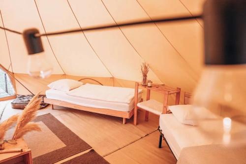 une chambre avec un lit et une table dans une tente dans l'établissement Family surfcamp Messanges, à Messanges