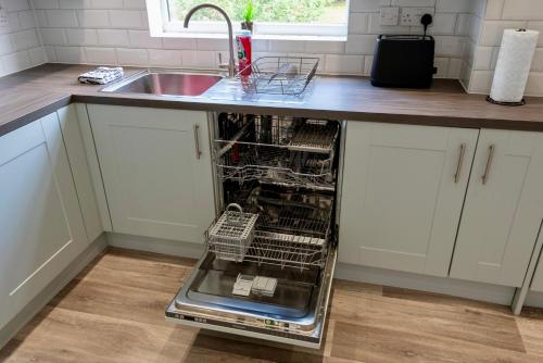 an empty dishwasher in a kitchen next to a sink at Modern Double Room with Broadband, Private TV and seating area - Room 4 in Solihull