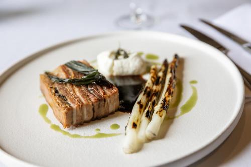 a white plate with some food on a table at Wood Hall Hotel & Spa in Wetherby