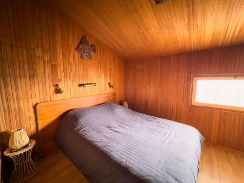 une chambre avec un lit dans une pièce en bois dans l'établissement Appartement vue mer Fréjus, à Fréjus