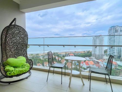 a room with chairs and a table and a large window at Monica Homestay - Căn hộ The Song Vũng Tàu in Vung Tau