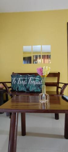 a bag sitting on a wooden table with a vase of flowers at Affordable Whole House Rent Transient in Butuan