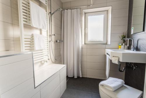 a white bathroom with a toilet and a sink at Apartmenthaus Königsallee in Bayreuth