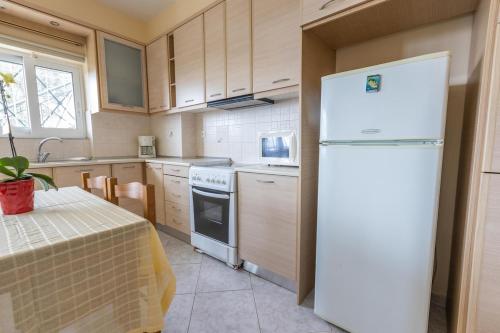 ギシオにあるMelina's apartmentの白い冷蔵庫とテーブルのあるキッチン