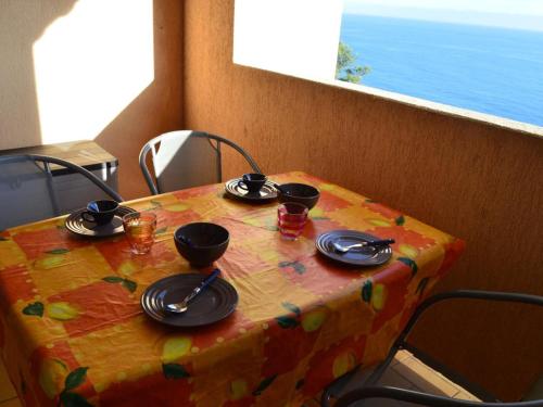 - une table avec des assiettes et des ustensiles en haut dans l'établissement Studio cabine Banyuls 4 pers, vue mer, parking, WiFi - FR-1-225C-1, à Banyuls-sur-Mer