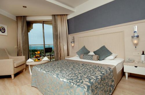 シダにあるSeamelia Beach Resort Hotel & SPAのベッドと椅子付きのホテルルーム