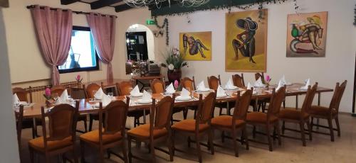 a large dining room with a long table and chairs at Šulentić sobe i restoran in Virovitica