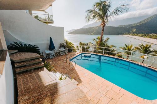 a swimming pool with a view of the ocean at Conforto, Vista linda e Pé na Areia | Barequeçaba in São Sebastião