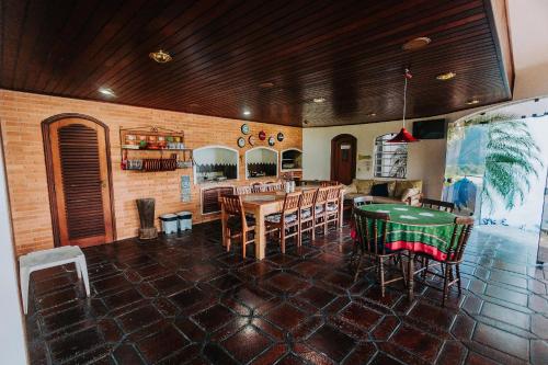 a dining room with a table and a pool table at Conforto, Vista linda e Pé na Areia | Barequeçaba in São Sebastião