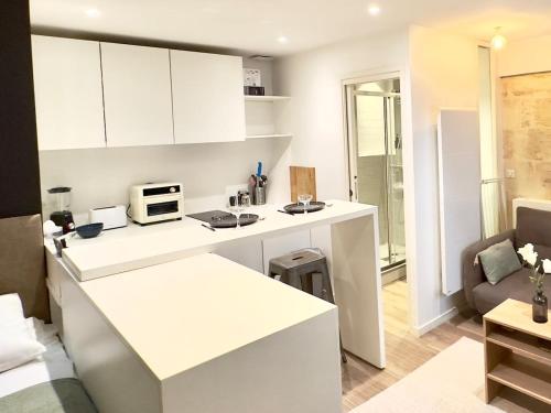 une cuisine avec des placards blancs et un comptoir blanc dans l'établissement Tourny Bordeaux Studio, à Bordeaux