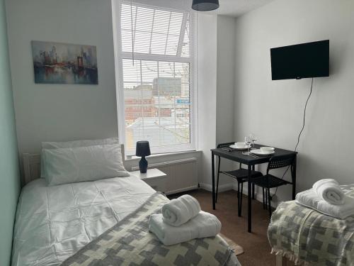 a bedroom with a bed and a desk and a window at Cosy and Comfortable Flat in Barnsley