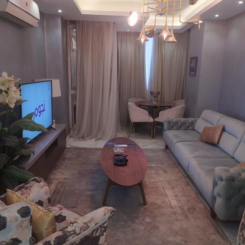 un salon avec un canapé et une télévision dans l'établissement شقه فاخره لايجار, au Caire