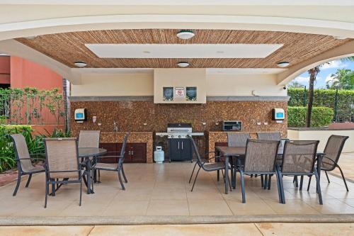 a patio with a table and chairs and a kitchen at Ocean Views, Rooftop Terrace & Resort Pools in Tamarindo