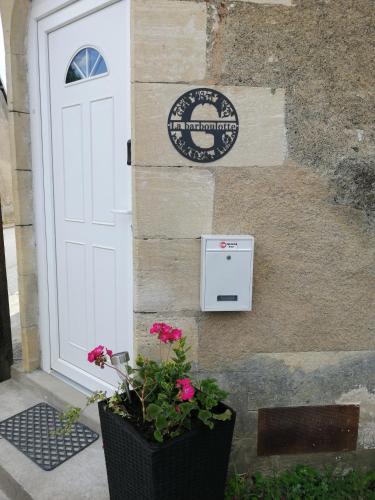 a door to a building with a mailbox and flowers at La Barboulotte in Ciez