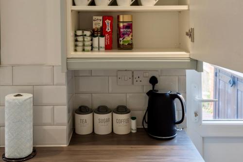 a kitchen counter with a coffee pot on a shelf at Modern Double Room with Broadband, Private TV in Shared House - Room 5 in Solihull