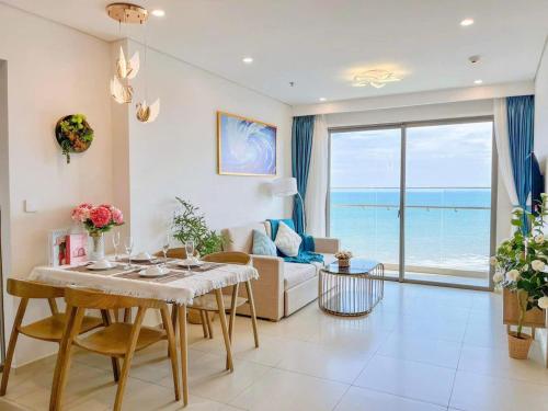 a living room with a table and a view of the ocean at The Song Boutique Apartment in Vung Tau
